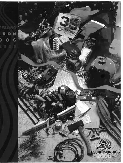 The 2000 Iron Dog program cover, a still life of race gear: a bib, boots, springs, a helmet, an axe, a clipboard and a safety inspection sheet.
