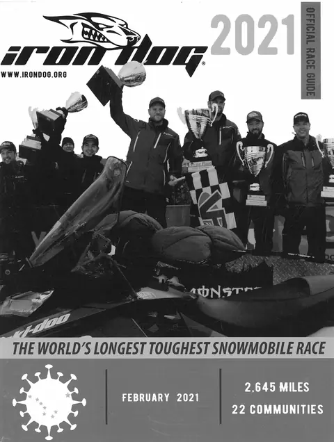 The 2021 Official Race Guide cover: a finish podium of racers holding trophies behind a race sled.